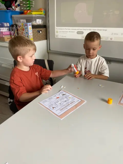 Dziewczynka trzyma filcowe jabłko podczas zajęć Sensory English