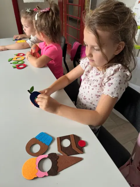 Nauczycielka czyta The Very Hungry Caterpillar przy filcowych owocach