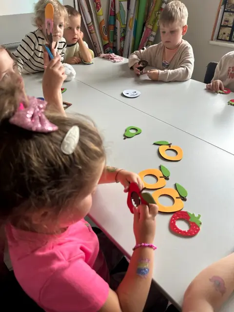 Dziewczynki układają filcowe owoce z The Very Hungry Caterpillar