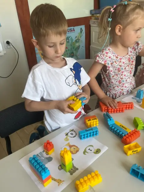 Dzieci układają klocki z angielskimi słowami
